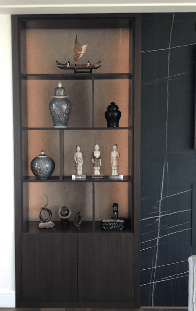 Custom-built shelving unit with curated decorative items, showcasing a blend of modern and traditional design elements by Campo Design in Victoria, BC.