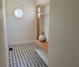 A hallway with a mirror and a shelf in it