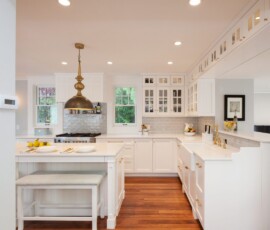 A kitchen with white cabinets and wooden floors